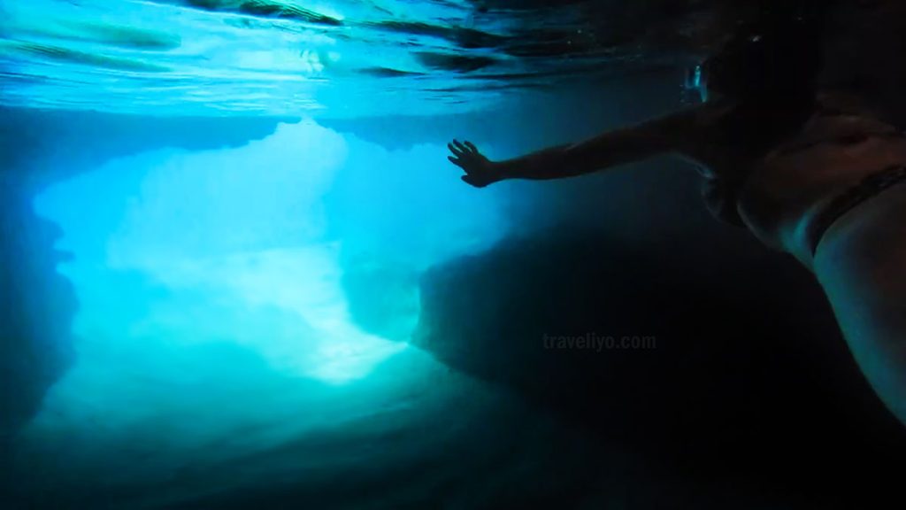 Traveler swimming through the entrance of the Blue Cave Vanuatu