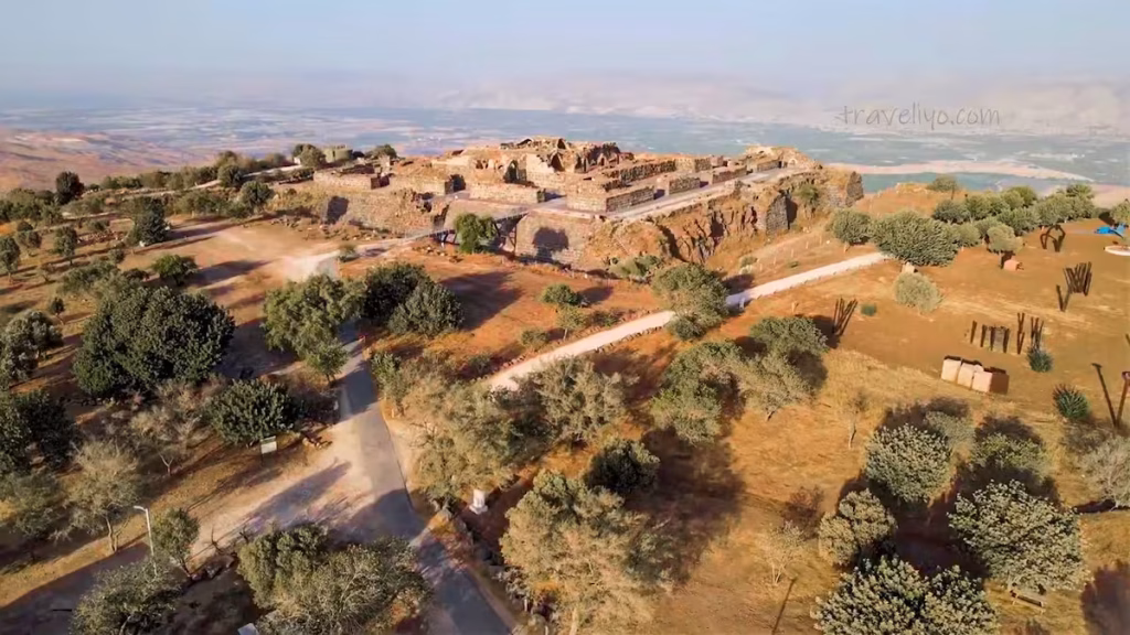 Aerial drone view of ancient historic castle ruins situated on a sprawling hilltop in Jordan.