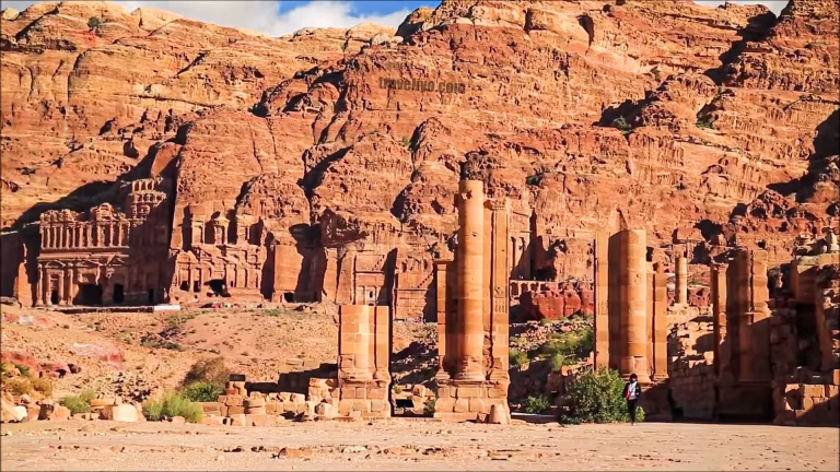 Ruins of the Great Temple and towering columns in the Lost City Petra under a clear blue sky.