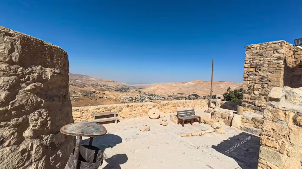A distant view of the Dead Sea and surrounding mountains seen from a high stone platform at Al Karak castle in jordan.