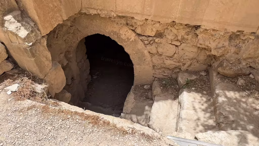 A dark stone doorway and steps leading down into the underground labyrinth of Al Karak Castle.