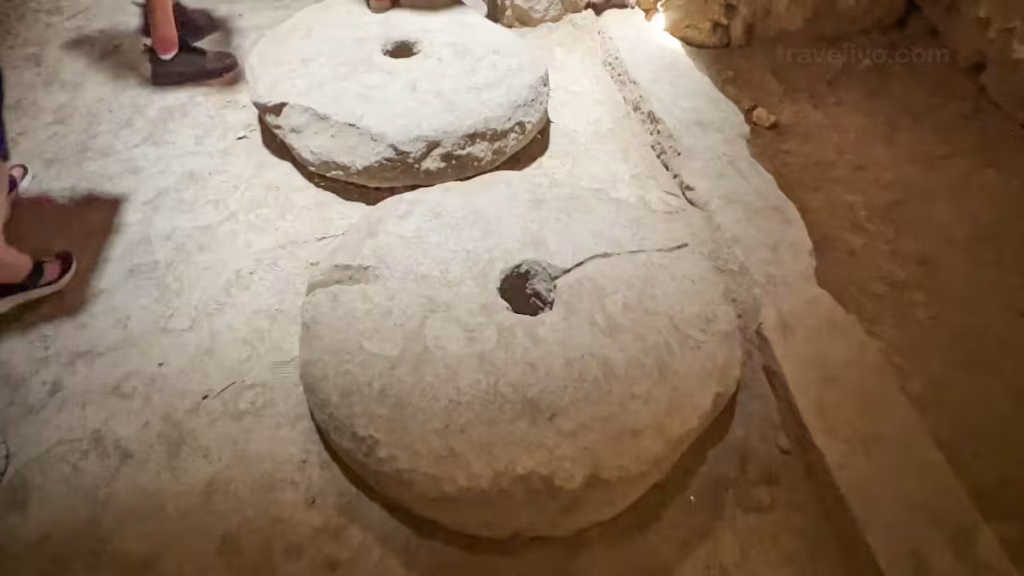 Two large, heavy circular stone millstones used as an olive press inside Al Karak Castle.