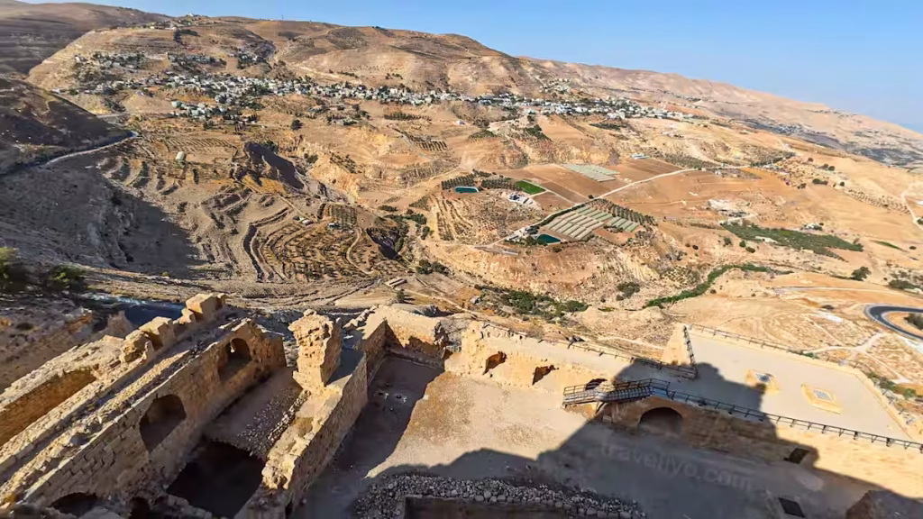 High angle bird's-eye view looking down into the lower ruins of the karak castle in jordan and the surrounding town.