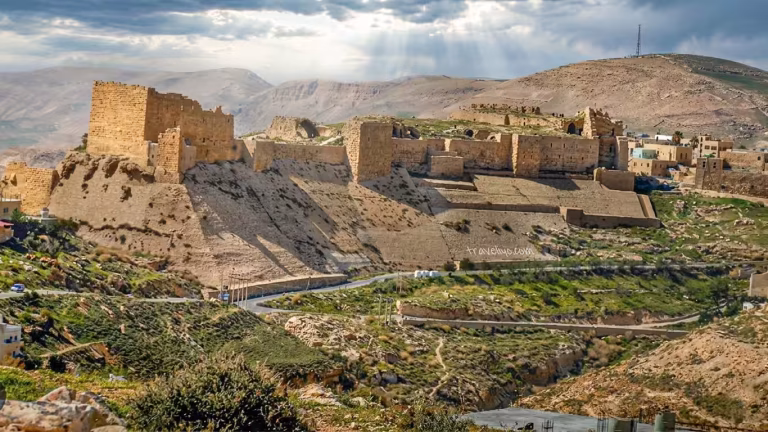 Panoramic distant view of the historic Karak castle in Jordan sitting on top of a steep hill.
