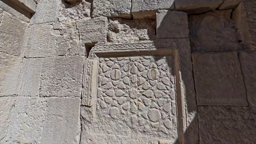 A detailed geometric star-patterned stone carving relief on an ancient wall inside Karak Castle.
