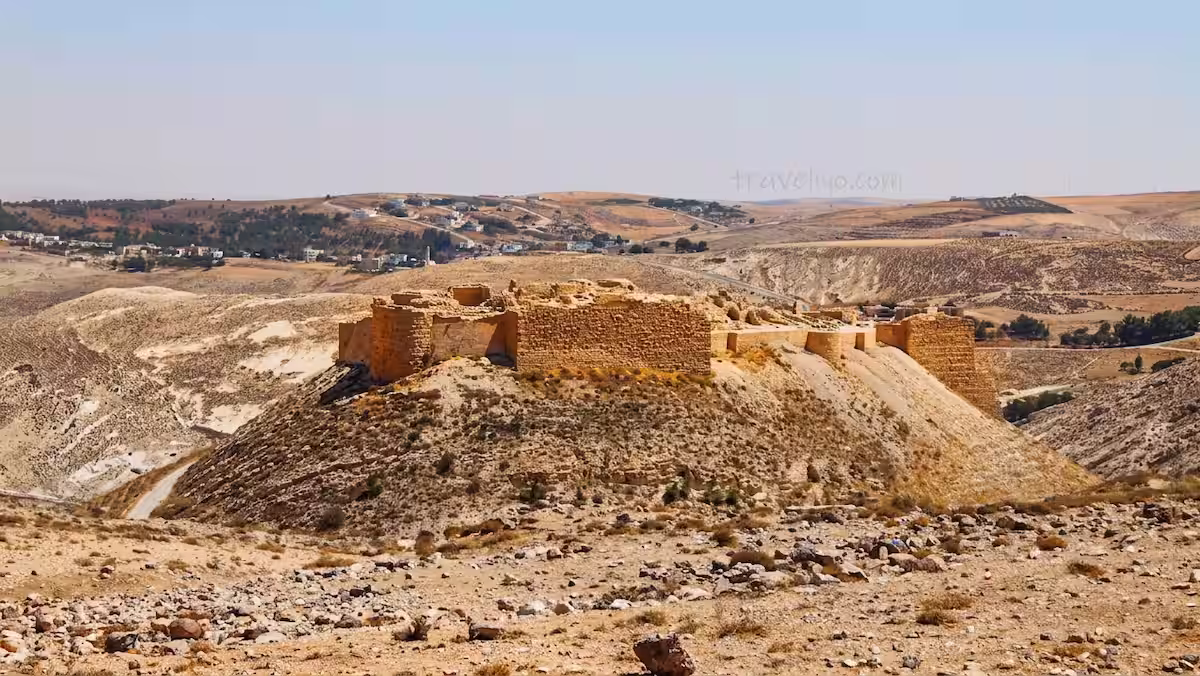 A striking distant view of Shobak Castle in Jordan perched on top of a desert mountain.