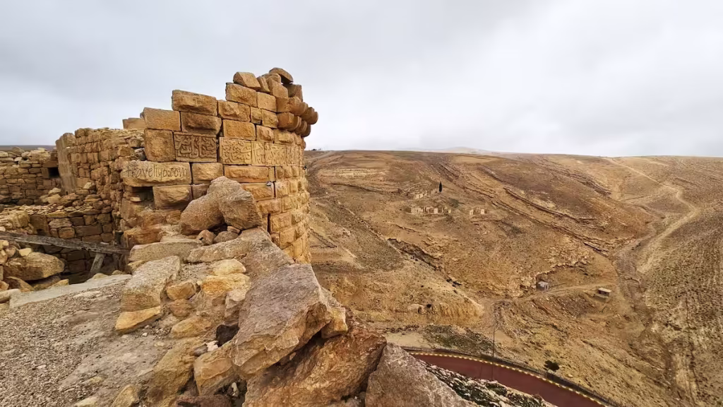 A high-angle view looking down at the surrounding valleys and rolling hills from Shobak Castle in Jordan.