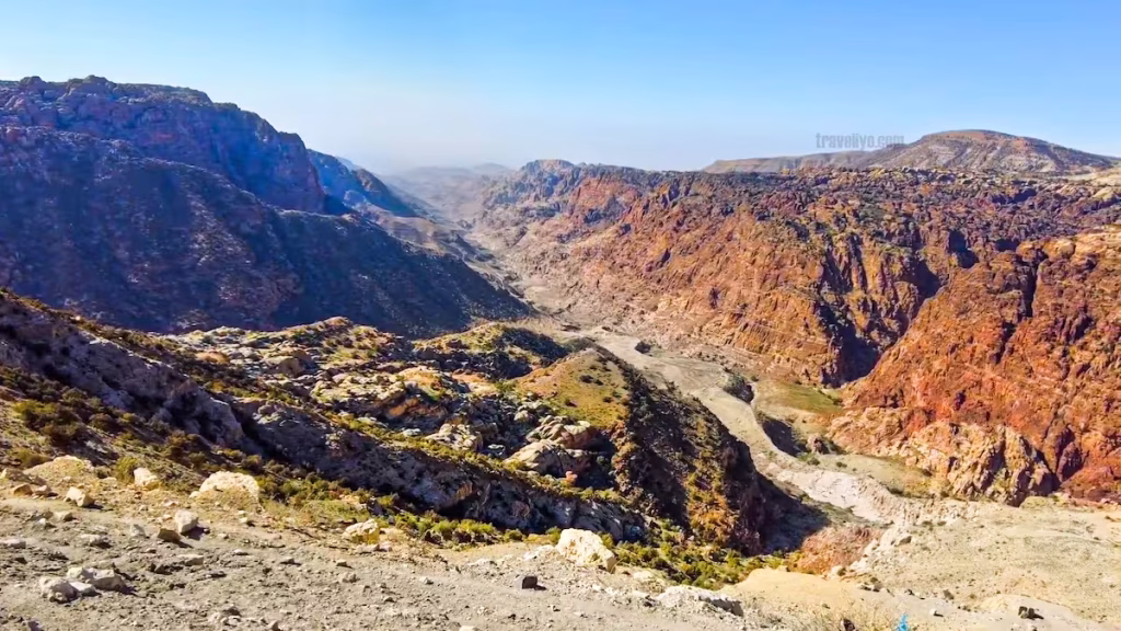 A small stream of water flowing through the dry valley floor in Wadi Dana.