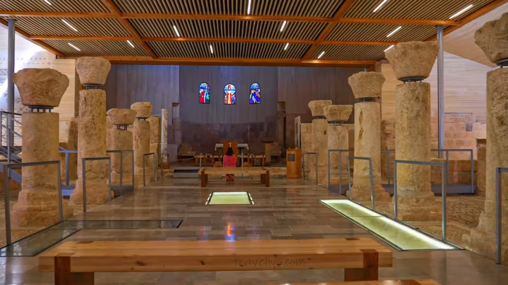 The modern interior of the Memorial Church of Moses featuring ancient columns and protective glass walkways.