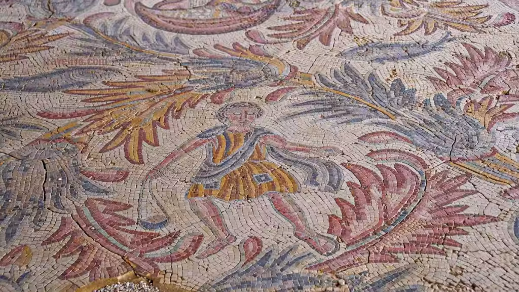 A close-up detail of a human figure and floral motifs in the Madaba Mount Nebo mosaic artwork.