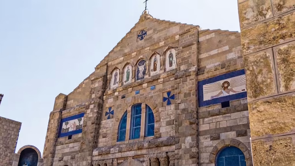The front facade of St. George's Church featuring a beautiful mosaic above the entrance in Madaba, Jordan.