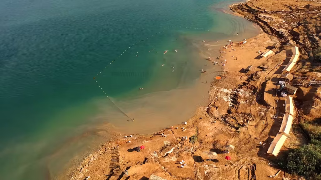 Aerial view of the Dead Sea coastline featuring salt deposits and resorts.