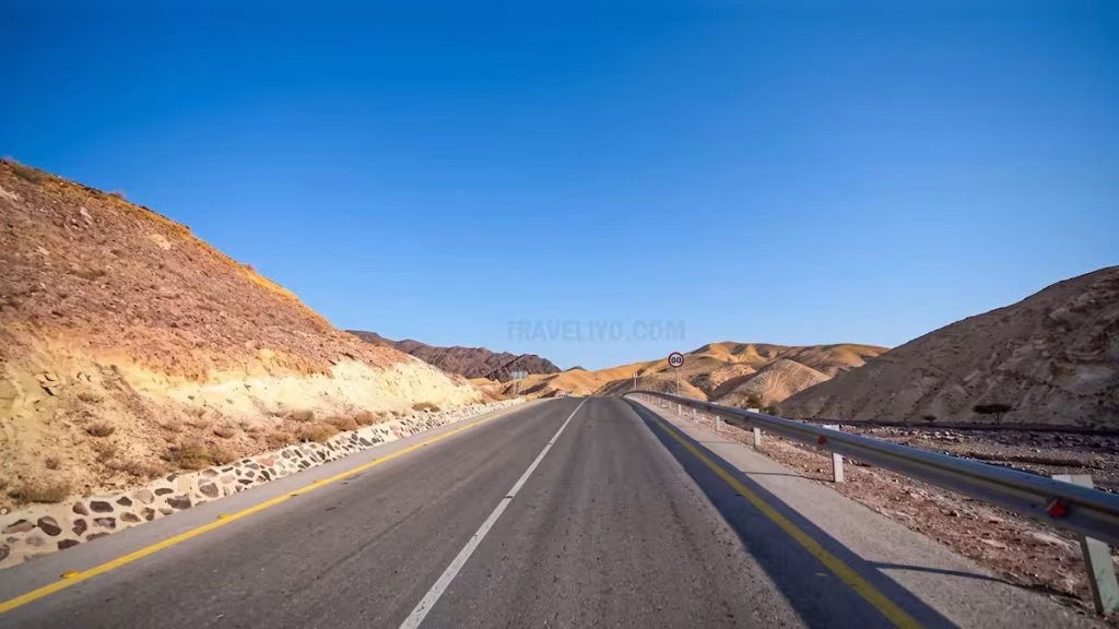 A smooth, modern highway stretching through the desert mountains of Jordan.