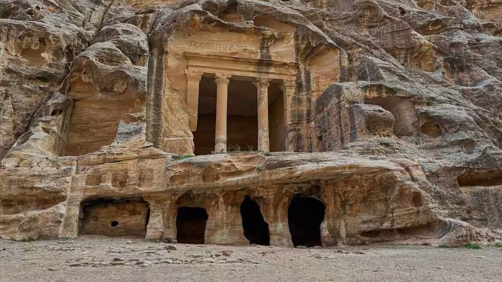 Ancient carved sandstone rock facade at Little Petra in Jordan.