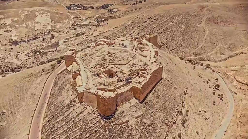 Aerial view of Shobak Castle sitting under the intense summer sun in the arid Jordan desert landscape.